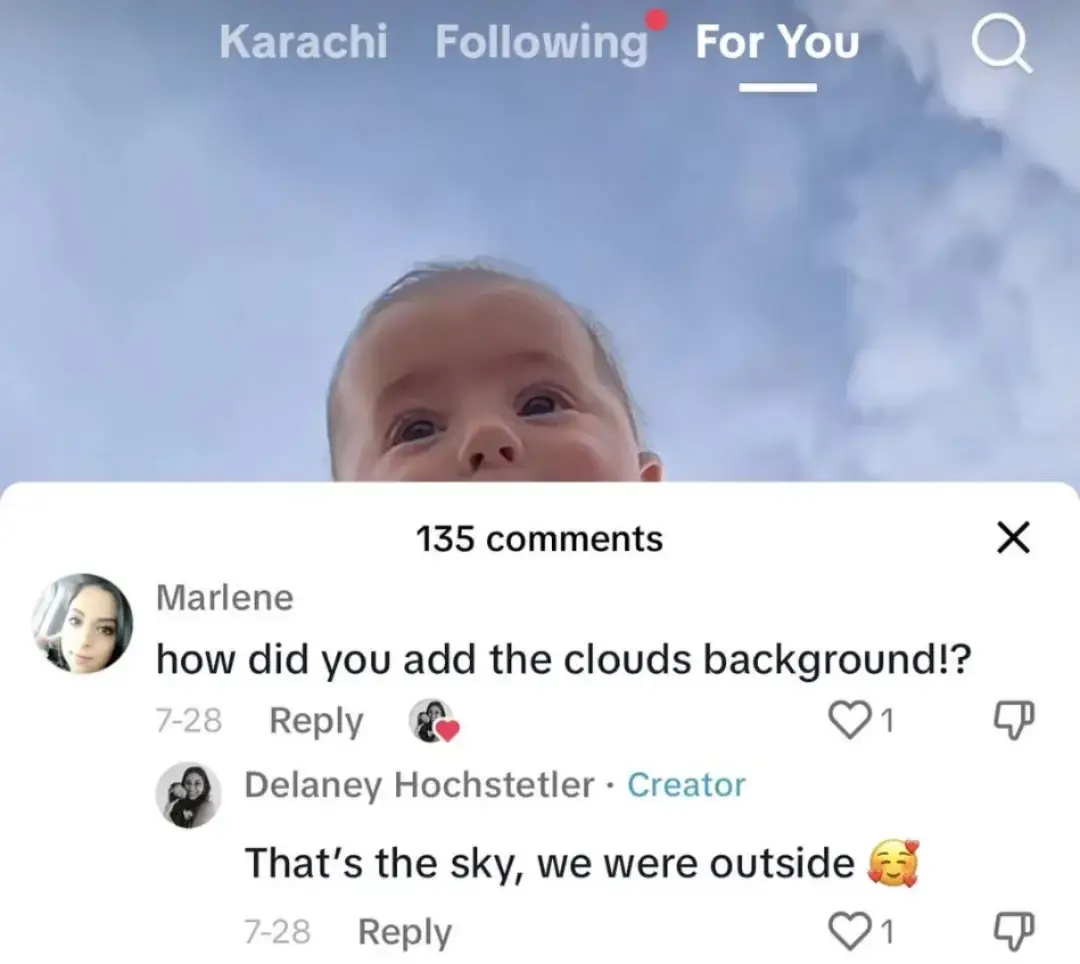 Screenshot of TikTok with the head of a child in front of a fairly clear sky with some clouds. Comment draw is open showing a comment from Marlene: "how did you add the clouds background!?" Delaney Hochstetler, the creator, replies: "That's the sky, we were outside  🥰".